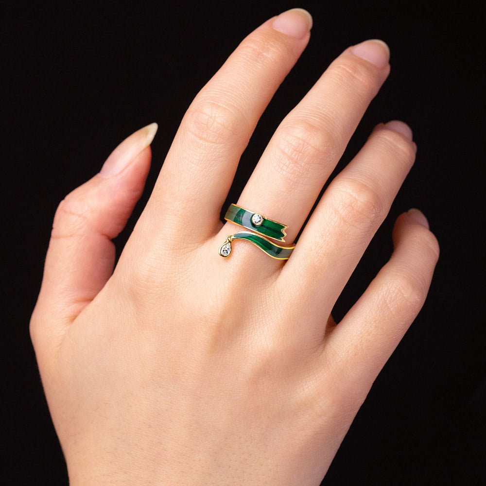 A blade of grass shaped ring made from enamel and a pear shaped diamond in 18 karat yellow gold by Solange Azagury-Partridge on hand