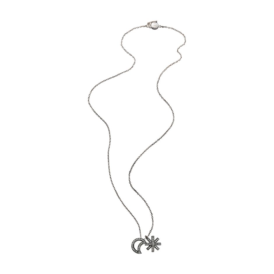 A moon and star motif pendant set with brilliant cut diamonds with a long chain in blackened 18 karat white gold by Solange Azagury-Partridge
