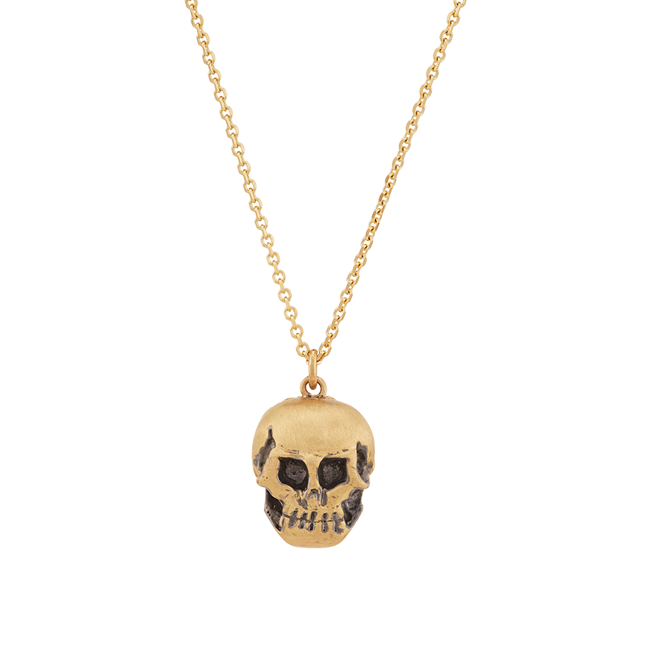 A pendant that respects the inevitability of death, half skull and half human face with diamond eyes and ruby red lacquered lips set in 18 karat yellow gold pendant on a chain by Solange Azagury-Partridge