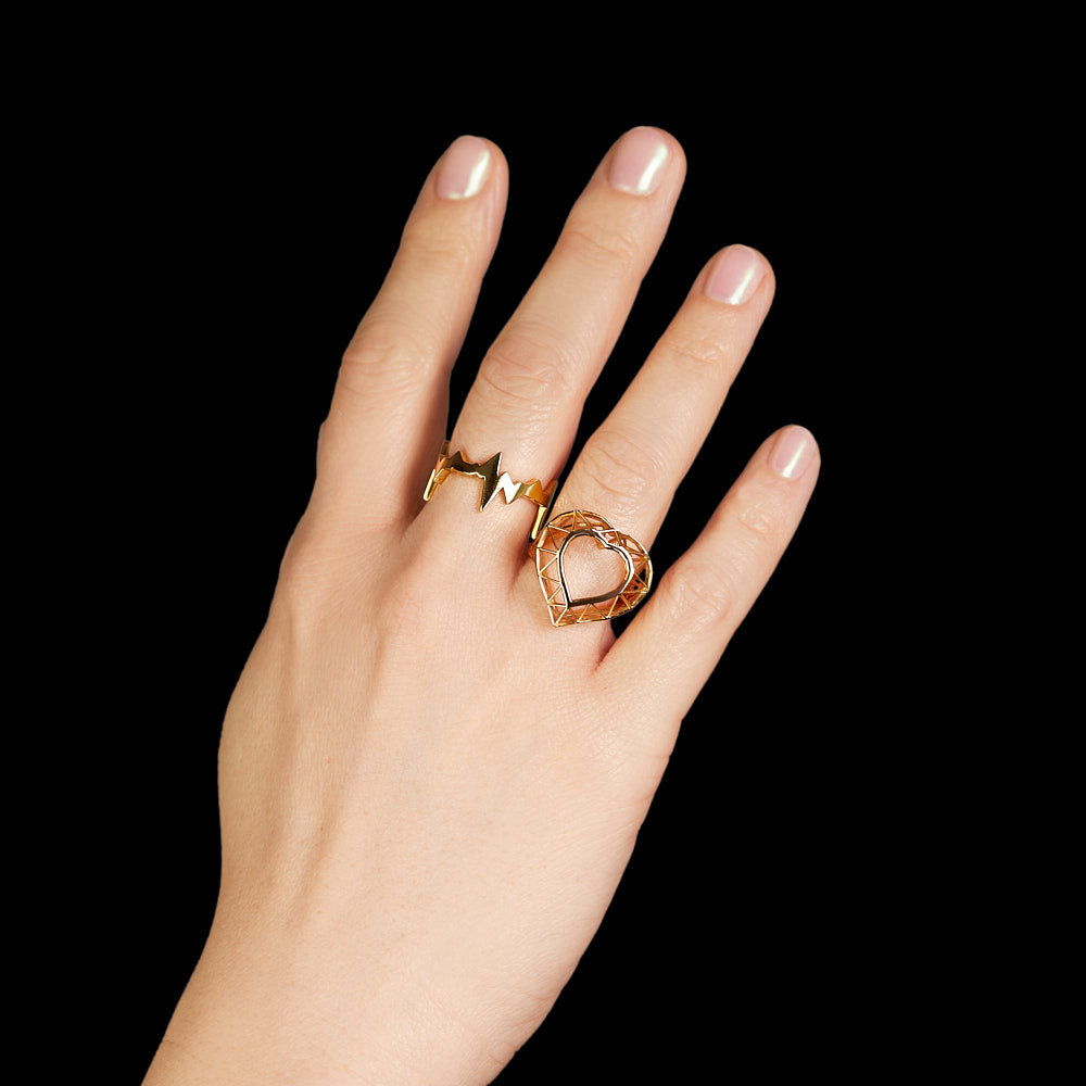 Heartbeat motif ring of a heartbeat line in 18 karat yellow gold by Solange Azagury-Partridge on hand with Skeleton Heart Ring