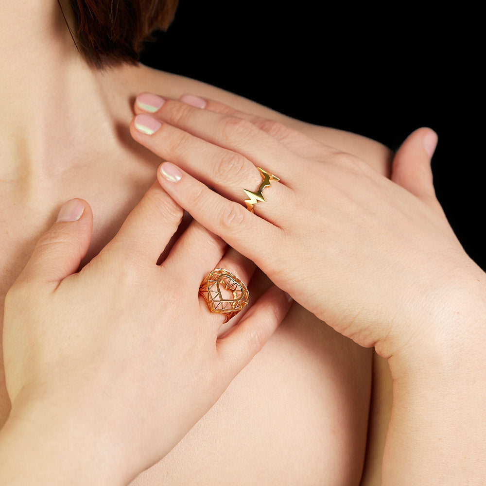 Heartbeat motif ring of a heartbeat line in 18 karat yellow gold by Solange Azagury-Partridge on model with skeleton heart ring