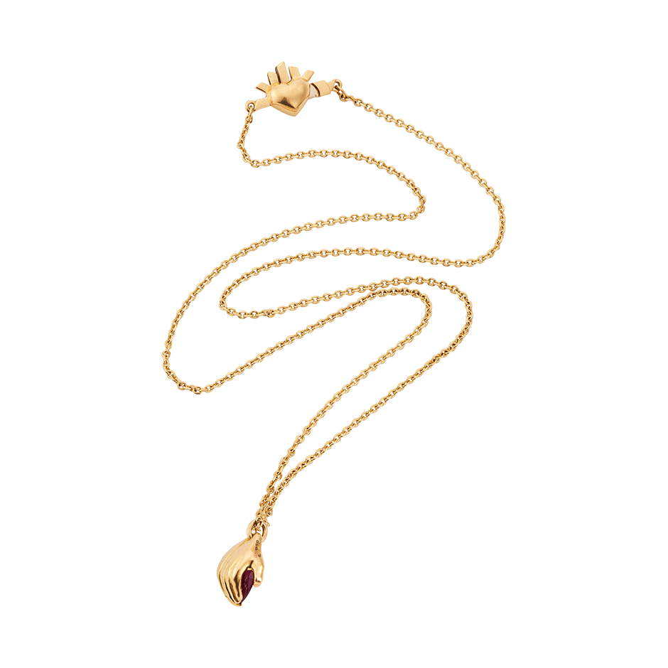 A pendant composed of a ruby gently held within a pair of 18k yellow gold hands with gold and a flaming heart yellow gold clap by Solange Azagury-Partridge